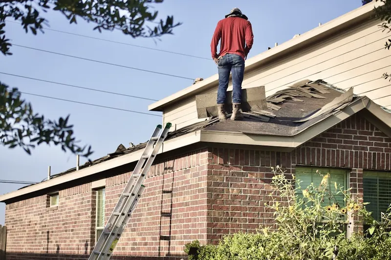 Professional roofer working on a residential roof in Enrose